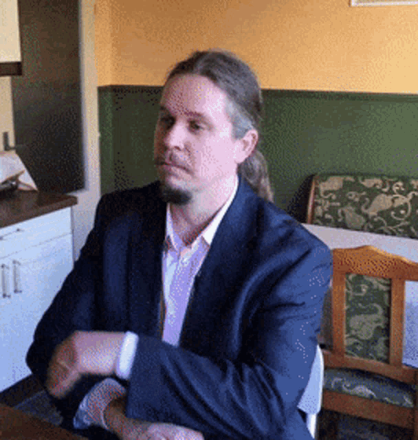 a man in a suit and tie is sitting at a table