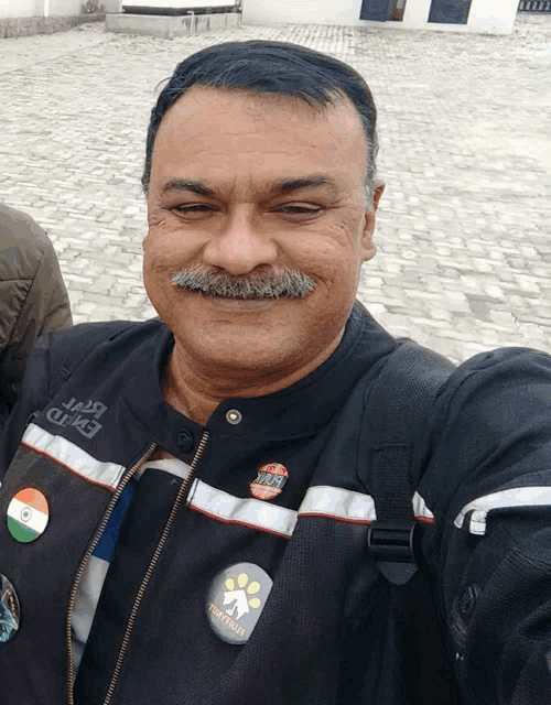 a man taking a selfie with a badge that says " triathlon "