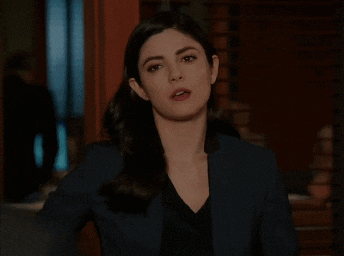 a woman wearing a black jacket and a black shirt looks at the camera