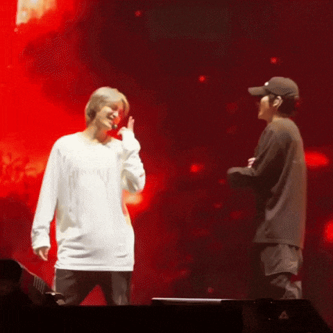 two men standing on a stage with one wearing a white shirt that says ' reebok ' on it