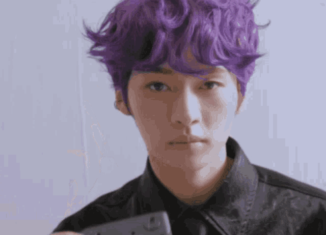 a man with purple hair is taking a picture of himself
