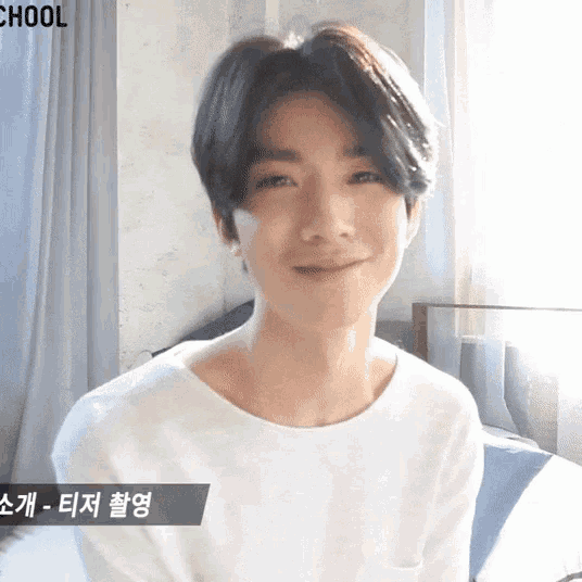 a young man wearing a white shirt with the word chool on the bottom right