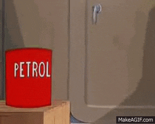 a cartoon cat is pointing at a red barrel of petrol .