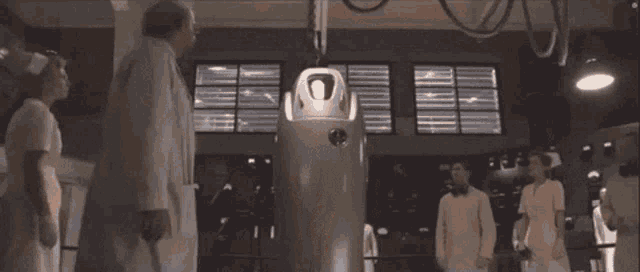 a shirtless man is being examined by a doctor and his face is projected on a machine