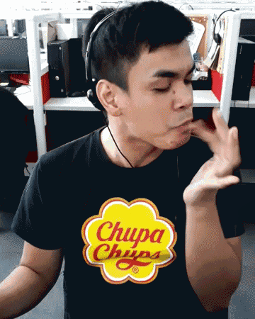 a man wearing headphones and a chupa chups shirt makes a funny face