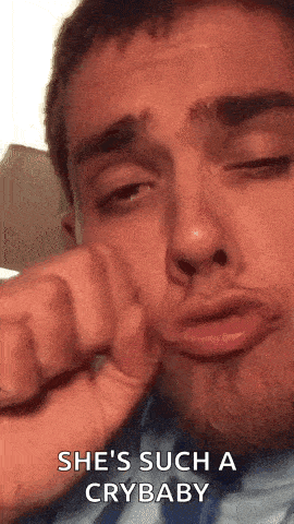 a man is crying and making a funny face with his hand on his face .