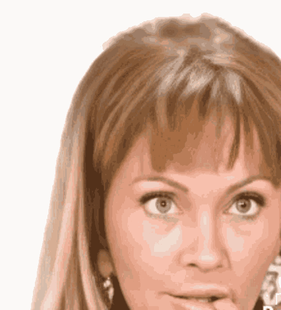 a close up of a woman 's face with a hand on her mouth