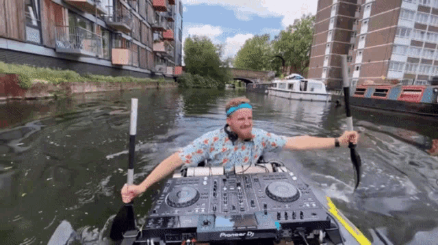 a man is in a kayak with a pioneer dj mixer