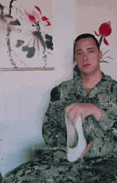 a man in a military uniform is holding a pair of socks