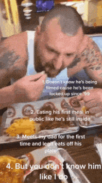 a man in a white tank top is eating a meal