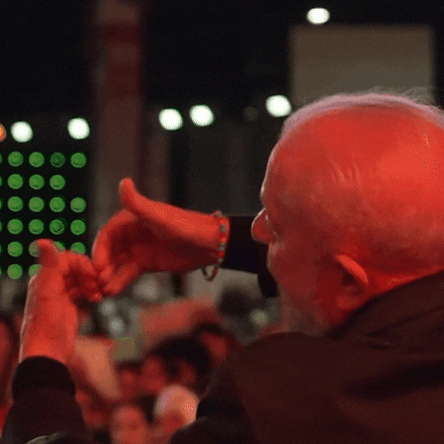 a man making a heart shape with his hands in the dark