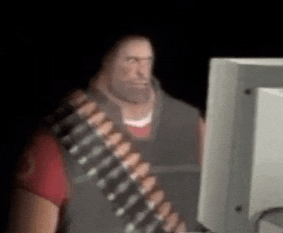 a man with a beard is standing in front of a computer screen .