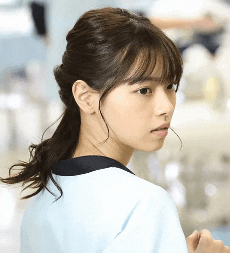 a close up of a woman 's face with a blue shirt on