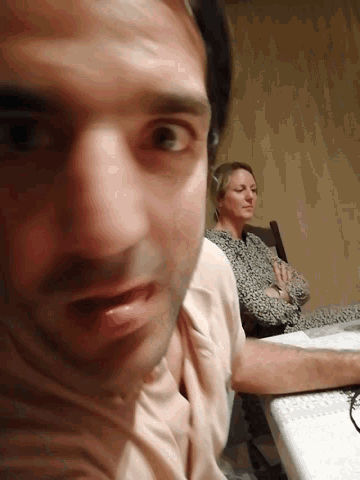 a man and a woman are laying on a bed and looking at each other