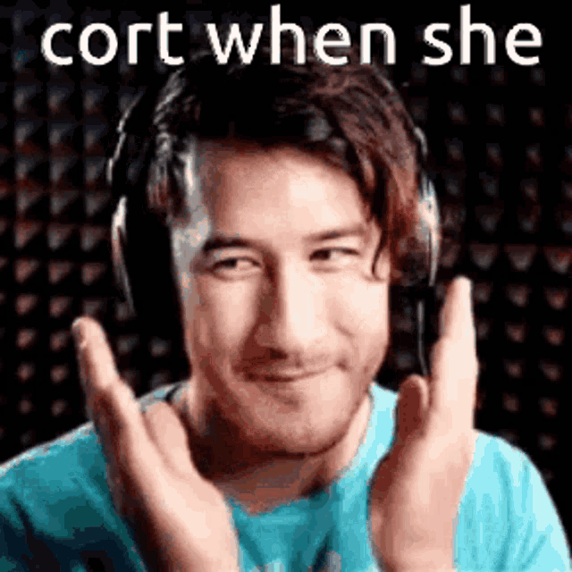 a man wearing headphones is making a funny face with his hands .