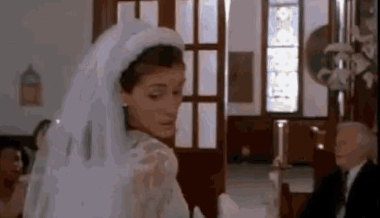 a woman in a wedding dress is standing in a church .