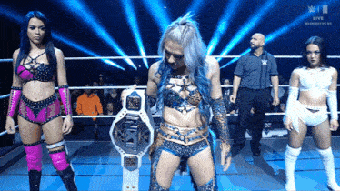 a woman in a wrestling ring holds a nxt belt
