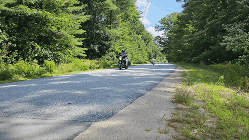 a person riding a motorcycle down a country road