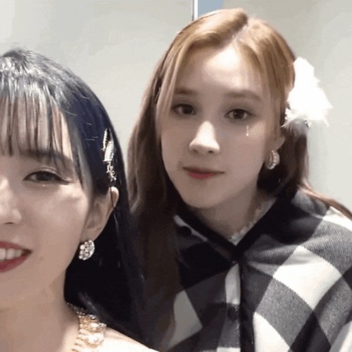 a woman with a flower in her hair is standing next to another woman