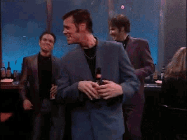 a man in a purple suit is holding a bottle of budweiser
