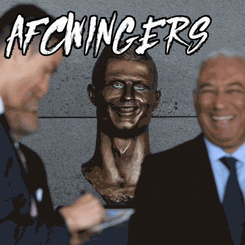 two men are standing next to a statue of a man with the words afcwinger 's written on it