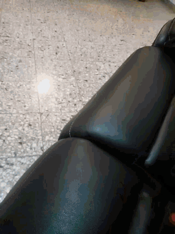 a black leather couch is sitting on a tile floor
