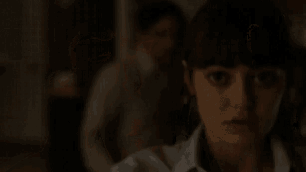 a woman is sitting in a chair with her eyes closed in a dark room .