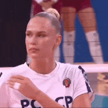 a female volleyball player wearing a white shirt with the word cp on it .
