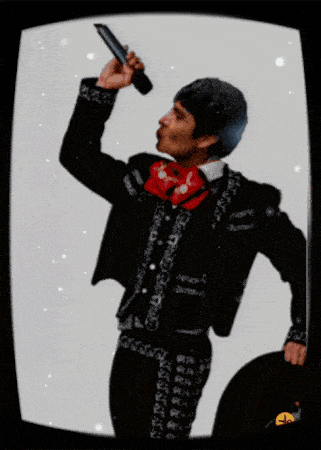 a man in a mariachi suit is pointing at something
