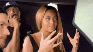 a woman is sitting in the back seat of a car talking to a man .