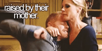 a woman is kissing a man on the cheek and the caption says raised by their mother .