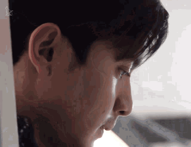 a close up of a man 's face with a star in the corner of his ear