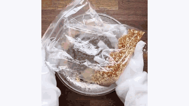 a plastic bag filled with nuts and powdered sugar is sitting on a microwave plate .