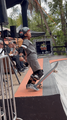 a person riding a skateboard on a ramp with a sign in the background that says ' ollie ' on it