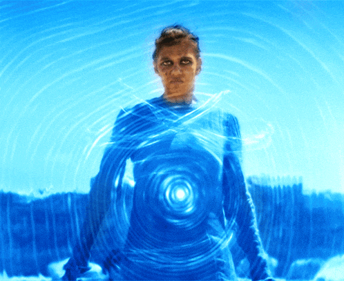 a woman in a blue shirt stands in front of a blue circle