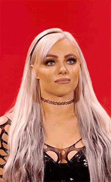 a woman with long blonde hair and blue eyes is wearing a choker necklace .
