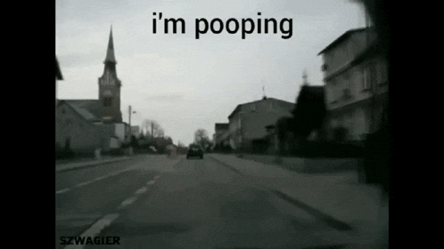 a car is driving down a street with the words " i 'm pooping " written on the bottom