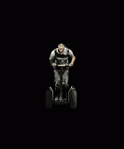 a man is riding a segway in front of a fire explosion