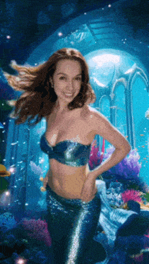 a woman in a mermaid costume is swimming in a pool