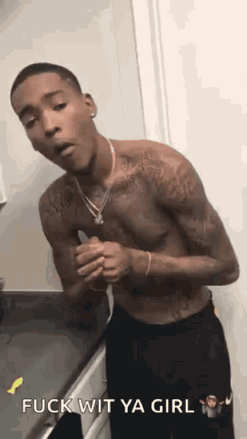 a shirtless man is standing in front of a counter with the words fuck wit ya girl written below him