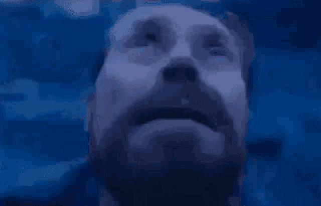 a close up of a man 's face with his eyes closed in the dark .