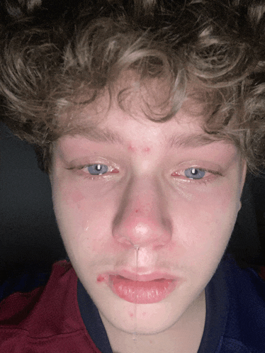 a close up of a young man 's face with tears running down his face