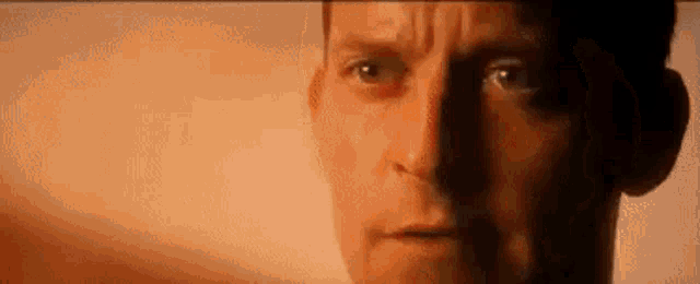 a close up of a man 's face with a shadow behind him .