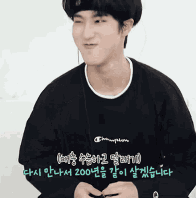 a young man wearing headphones and a black champion sweatshirt