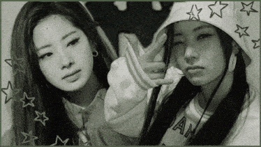 a black and white photo of two girls one wearing a hoodie and the other wearing a shirt that says ah