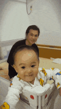 a baby wearing a winnie the pooh outfit is smiling while being held by a man