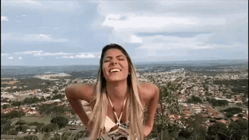 a woman in a bikini stands on top of a hill with her hands on her hips
