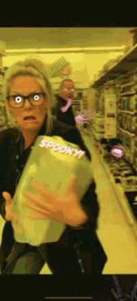 a woman holding a bag of spooky popcorn in a store