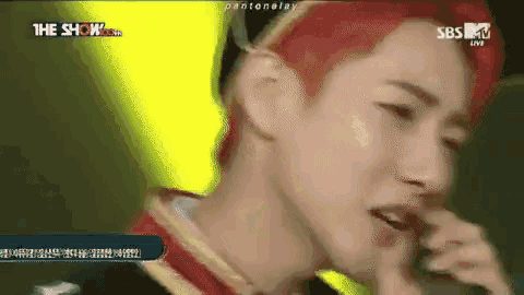 a man with red hair is singing into a microphone on sbs mv live