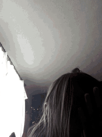 a person standing in front of a white wall with a light on